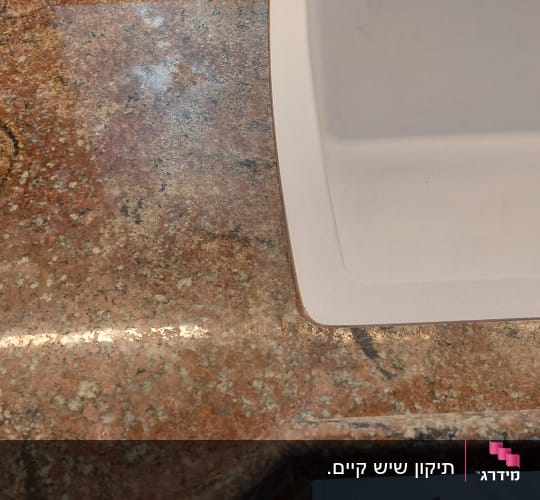 שיש חום עם כיור לבן במטבח